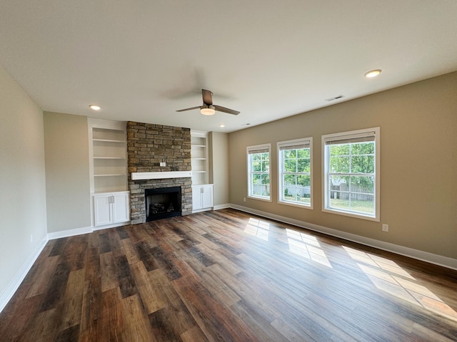 unfurnished living room featuring a fireplace, ceiling fan, built in features, and wood-type flooring