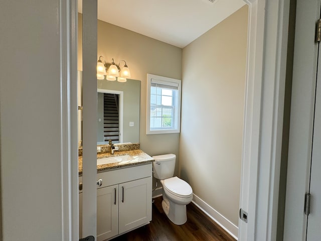 bathroom featuring wood-type flooring, vanity, and toilet