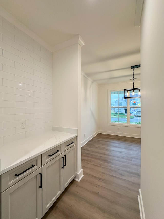 hallway with dark hardwood / wood-style flooring, an inviting chandelier, and crown molding