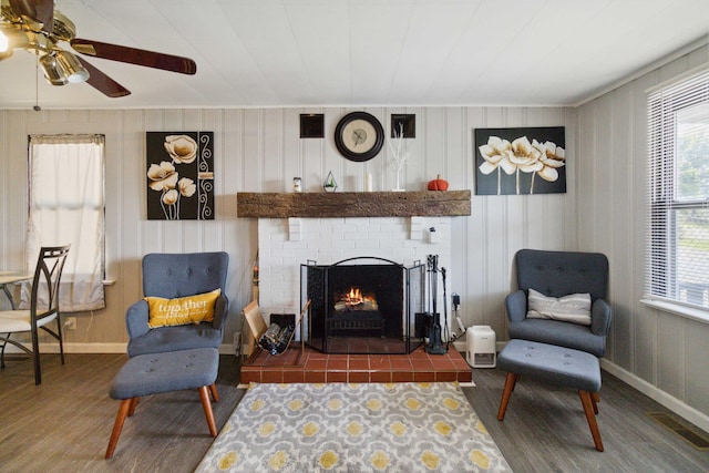 living room with dark hardwood / wood-style floors, a brick fireplace, and ceiling fan