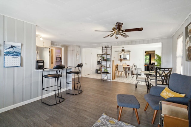 kitchen featuring stainless steel refrigerator, white cabinetry, a kitchen breakfast bar, a kitchen island, and light wood-type flooring