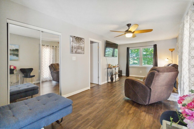 living room featuring ceiling fan and dark wood-type flooring