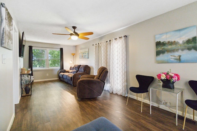 living room featuring ceiling fan and dark wood-type flooring