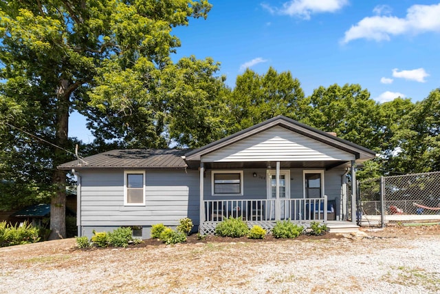 bungalow-style home featuring a porch and a fenced in pool