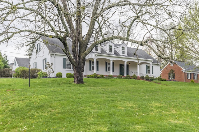 cape cod home with a porch, a front yard, and a shingled roof