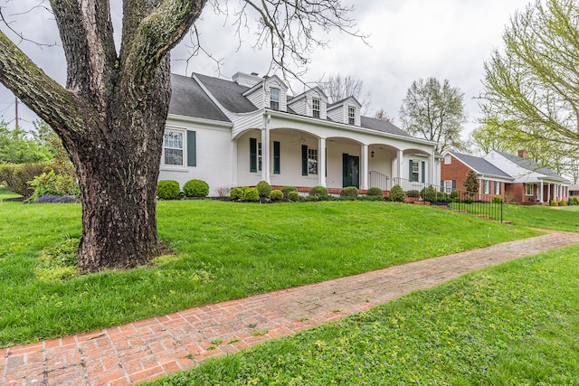 cape cod home featuring a front lawn and covered porch