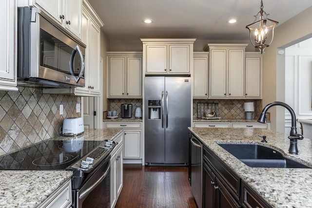 kitchen featuring decorative backsplash, sink, light stone counters, and stainless steel appliances