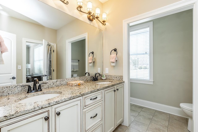 bathroom featuring tile patterned flooring, vanity, and toilet