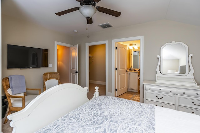 bedroom featuring ensuite bath, a spacious closet, ceiling fan, lofted ceiling, and a closet