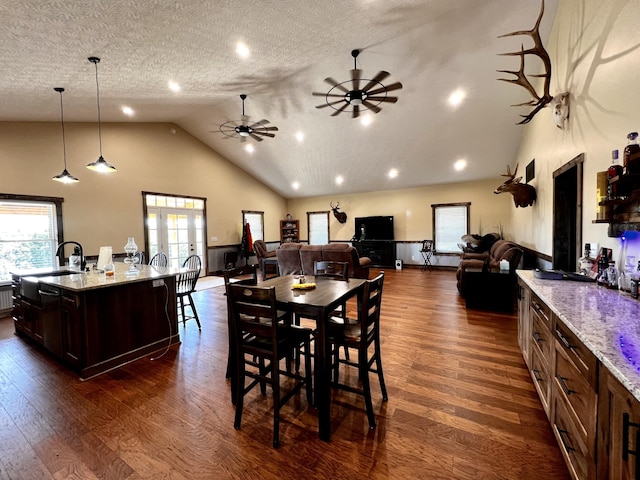 dining area featuring a textured ceiling, ceiling fan, dark wood-type flooring, and sink