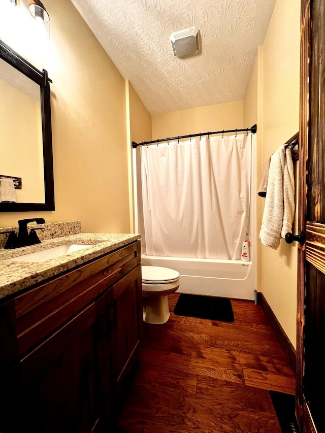 full bathroom with vanity, hardwood / wood-style flooring, toilet, shower / bathtub combination with curtain, and a textured ceiling