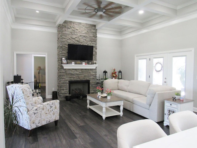 living room featuring beamed ceiling, a ceiling fan, dark wood-style floors, coffered ceiling, and a stone fireplace