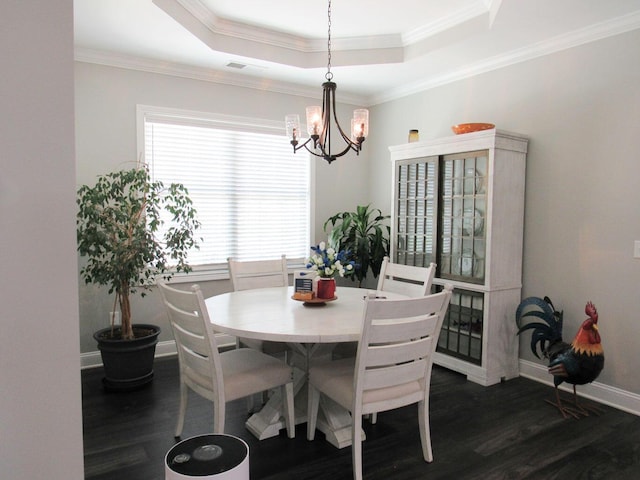 dining area featuring dark wood-style flooring, crown molding, a chandelier, a raised ceiling, and baseboards