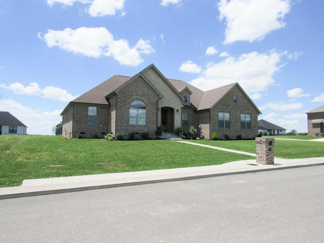 french country home with brick siding and a front yard