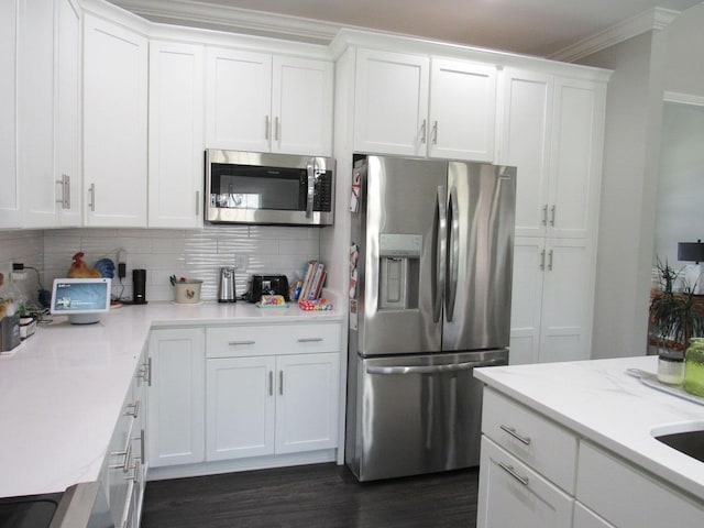 kitchen featuring white cabinetry, crown molding, stainless steel appliances, and tasteful backsplash