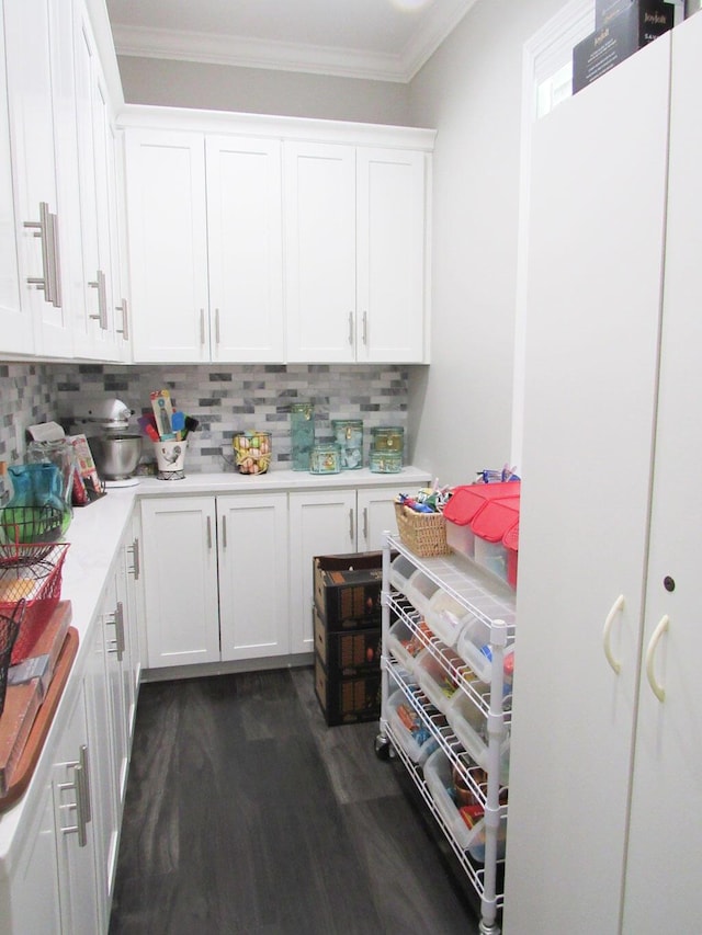 kitchen with white cabinetry, light countertops, tasteful backsplash, ornamental molding, and dark wood-style floors