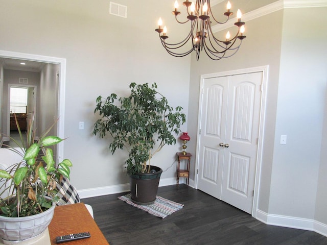 foyer entrance featuring an inviting chandelier, visible vents, baseboards, and dark wood-type flooring
