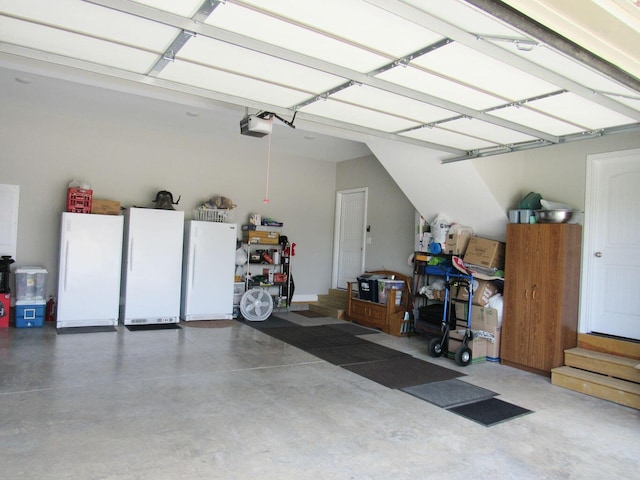 garage featuring freestanding refrigerator and a garage door opener