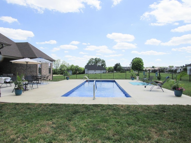 view of swimming pool featuring a yard and fence