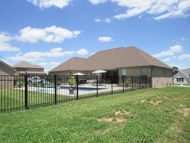 view of swimming pool featuring a lawn, a patio, a fenced in pool, and fence