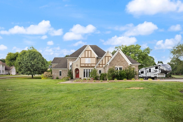 tudor-style house featuring a front lawn