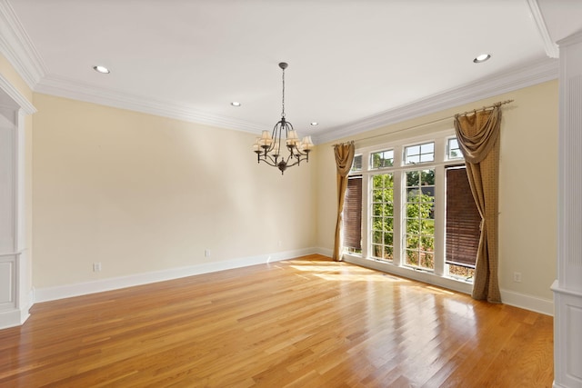 unfurnished room featuring a chandelier, crown molding, and light hardwood / wood-style floors