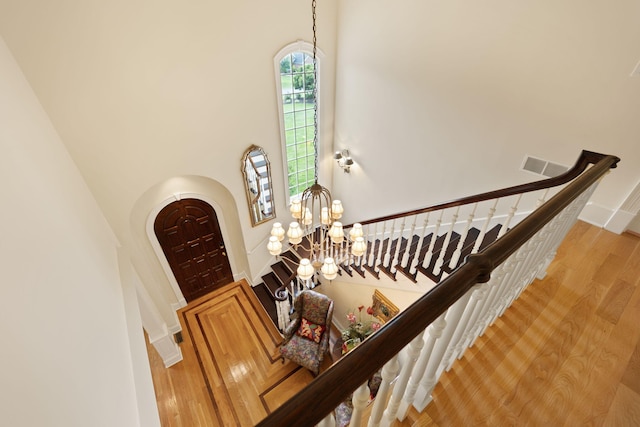 stairs with a notable chandelier