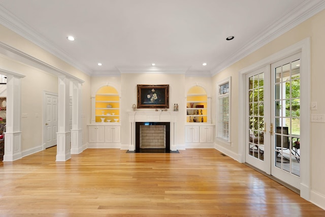 unfurnished living room featuring decorative columns, built in features, french doors, and light wood-type flooring