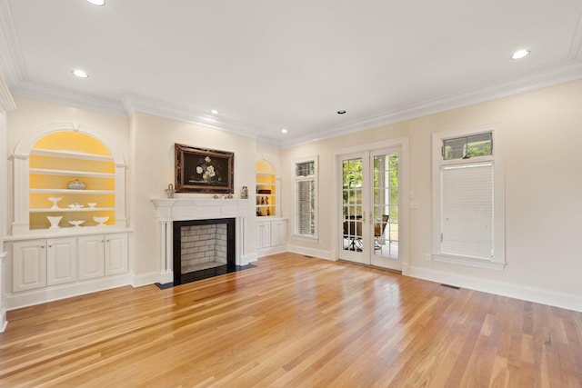 unfurnished living room with built in features, ornamental molding, french doors, and light hardwood / wood-style flooring