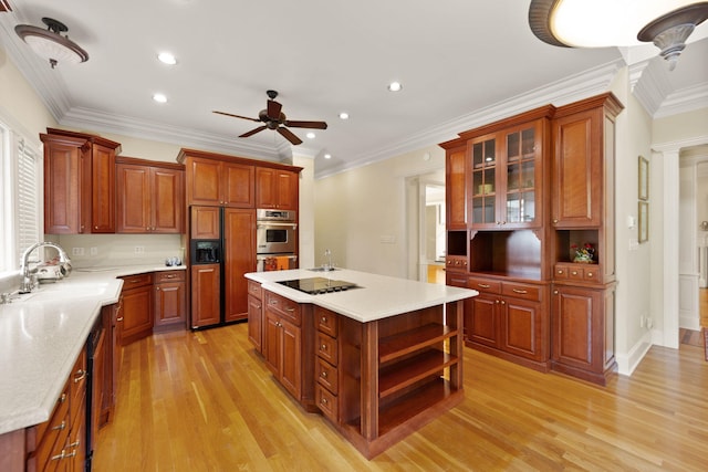 kitchen with ornamental molding, ceiling fan, sink, a center island, and light hardwood / wood-style floors