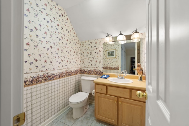 bathroom with tile patterned floors, vanity, toilet, and vaulted ceiling