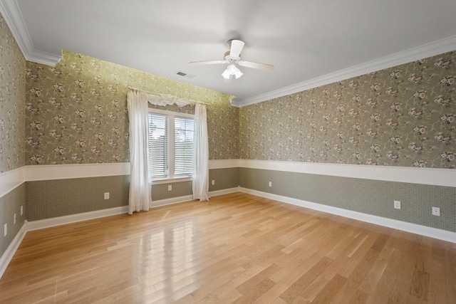 spare room with ceiling fan, ornamental molding, and light hardwood / wood-style flooring