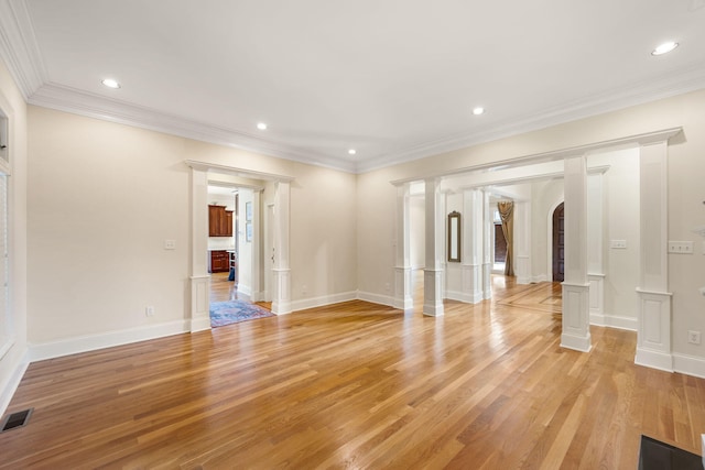 spare room with ornate columns, crown molding, and light hardwood / wood-style flooring