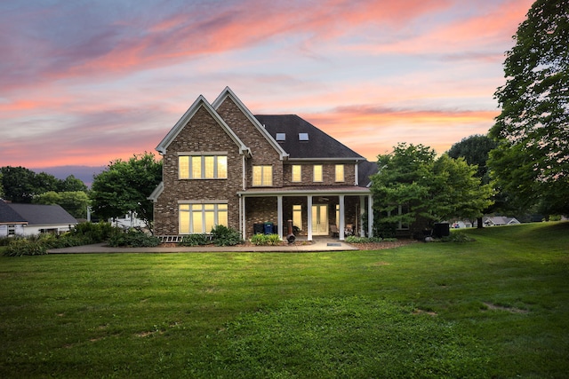 back house at dusk with a lawn