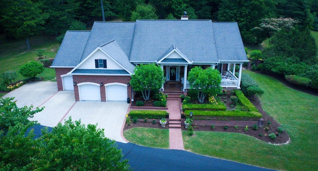 view of front of home with a porch, a garage, and a front lawn