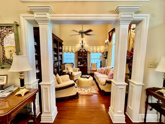 living room featuring built in features, ceiling fan, hardwood / wood-style flooring, and ornate columns