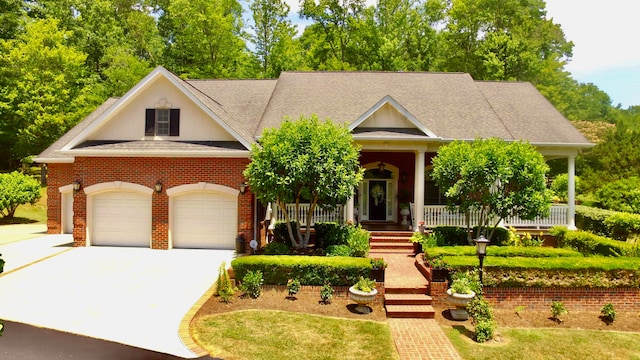 view of front of property with a front yard, a garage, and covered porch