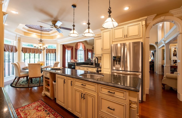 kitchen featuring dark hardwood / wood-style flooring, ornamental molding, a raised ceiling, and a kitchen island with sink