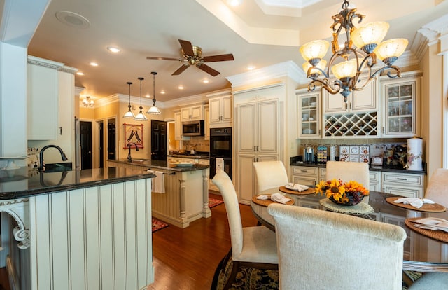 kitchen featuring dark hardwood / wood-style flooring, backsplash, a center island, ornamental molding, and pendant lighting