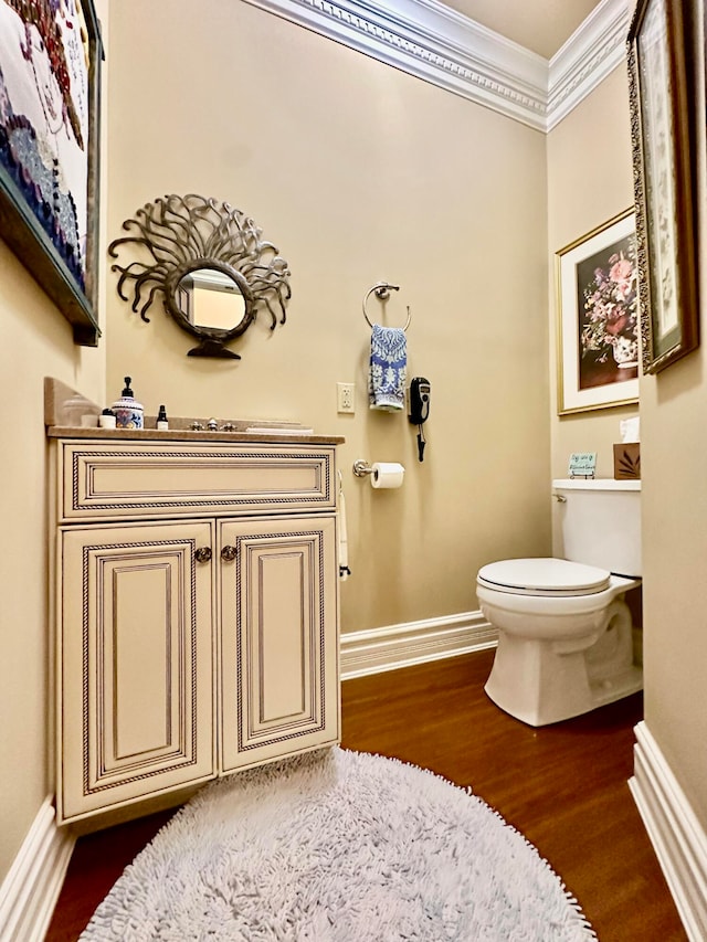 bathroom featuring ornamental molding, hardwood / wood-style floors, and toilet