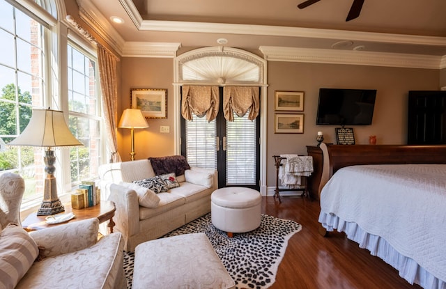 bedroom featuring dark hardwood / wood-style floors, ceiling fan, a tray ceiling, and crown molding