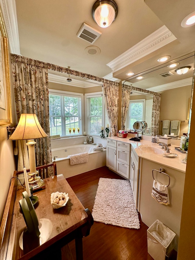 bathroom featuring hardwood / wood-style floors, ornamental molding, a bath, and large vanity