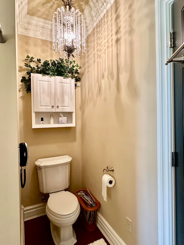 bathroom with a notable chandelier, ornamental molding, and toilet