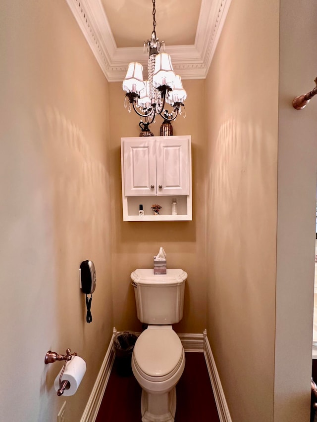 bathroom featuring ornamental molding, an inviting chandelier, and toilet