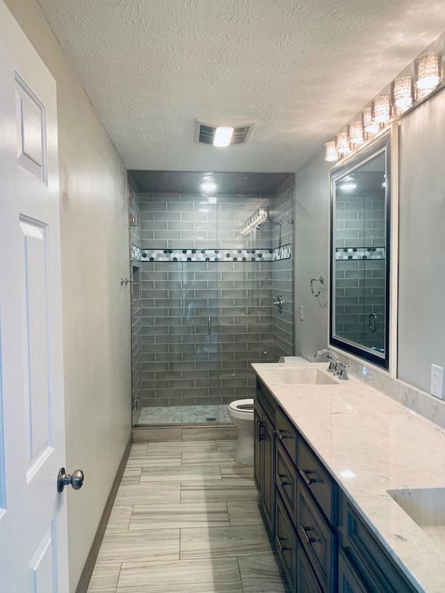 bathroom with walk in shower, toilet, a textured ceiling, and vanity