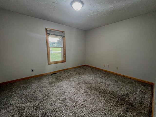 carpeted empty room with a textured ceiling