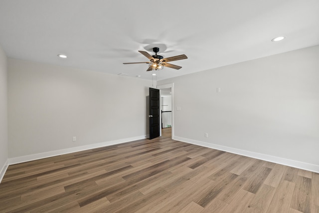 empty room with hardwood / wood-style floors and ceiling fan