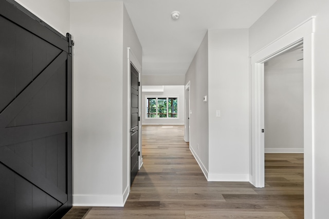 hallway with hardwood / wood-style floors and a barn door