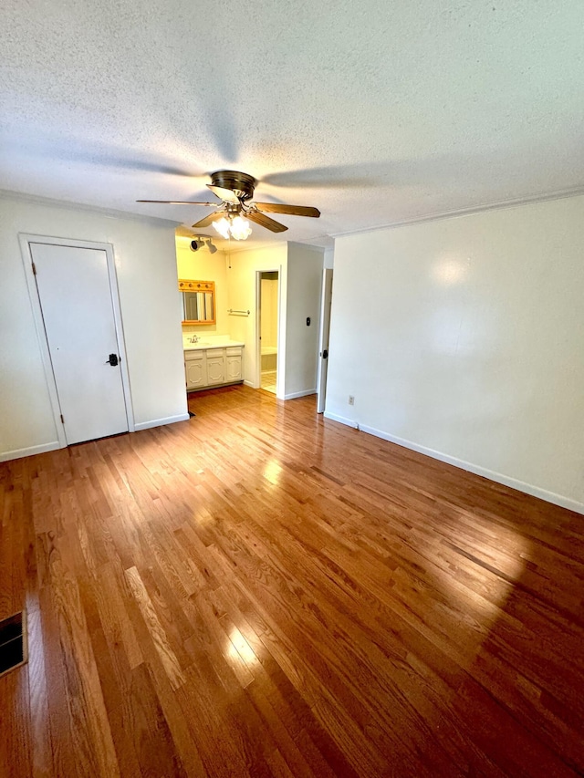 unfurnished living room featuring a textured ceiling and light hardwood / wood-style flooring