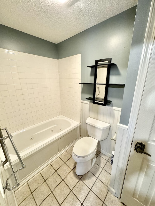 bathroom featuring toilet, tiled shower / bath, and a textured ceiling